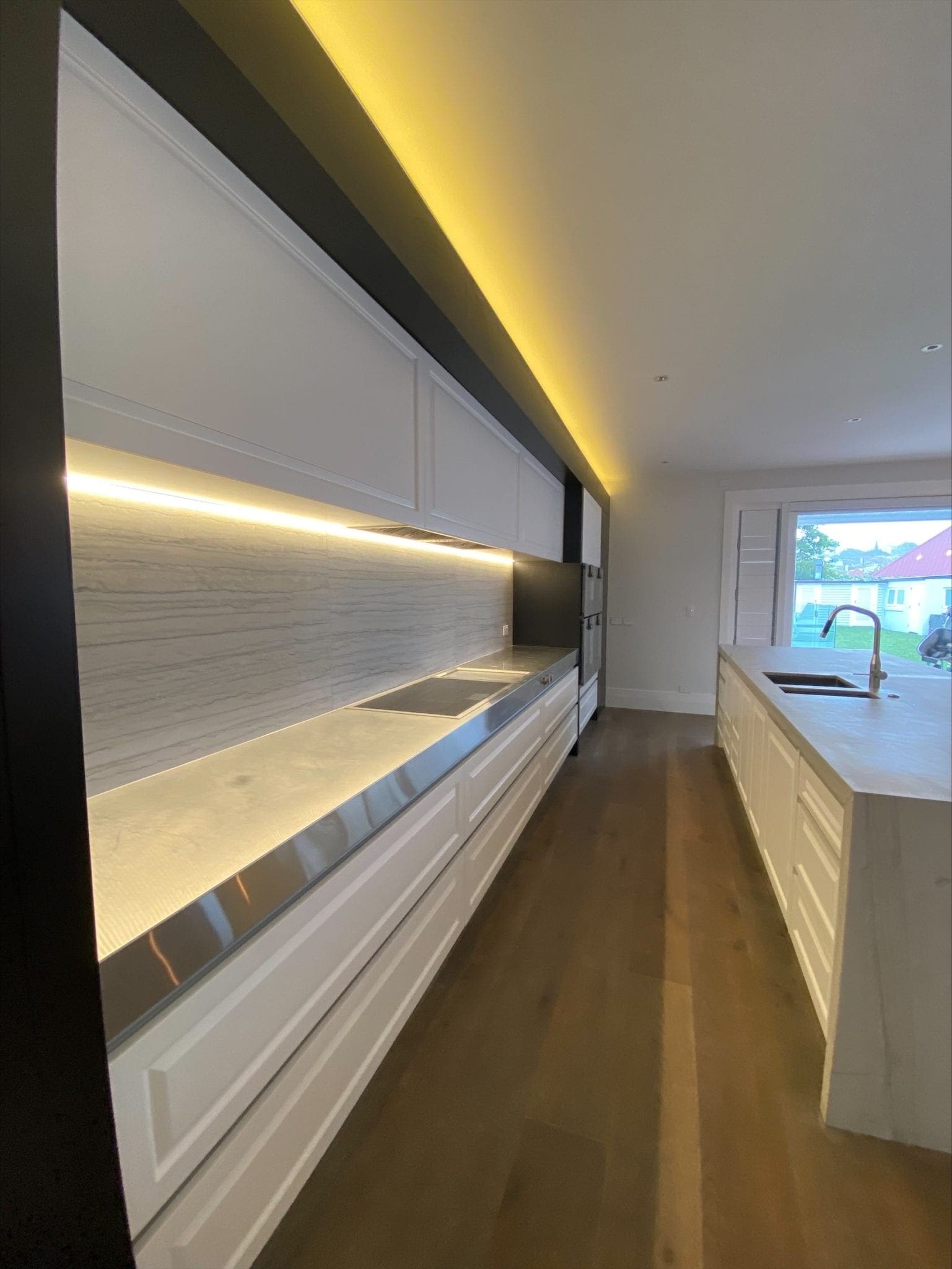 Kitchen cabinets with light strips installed and lit.