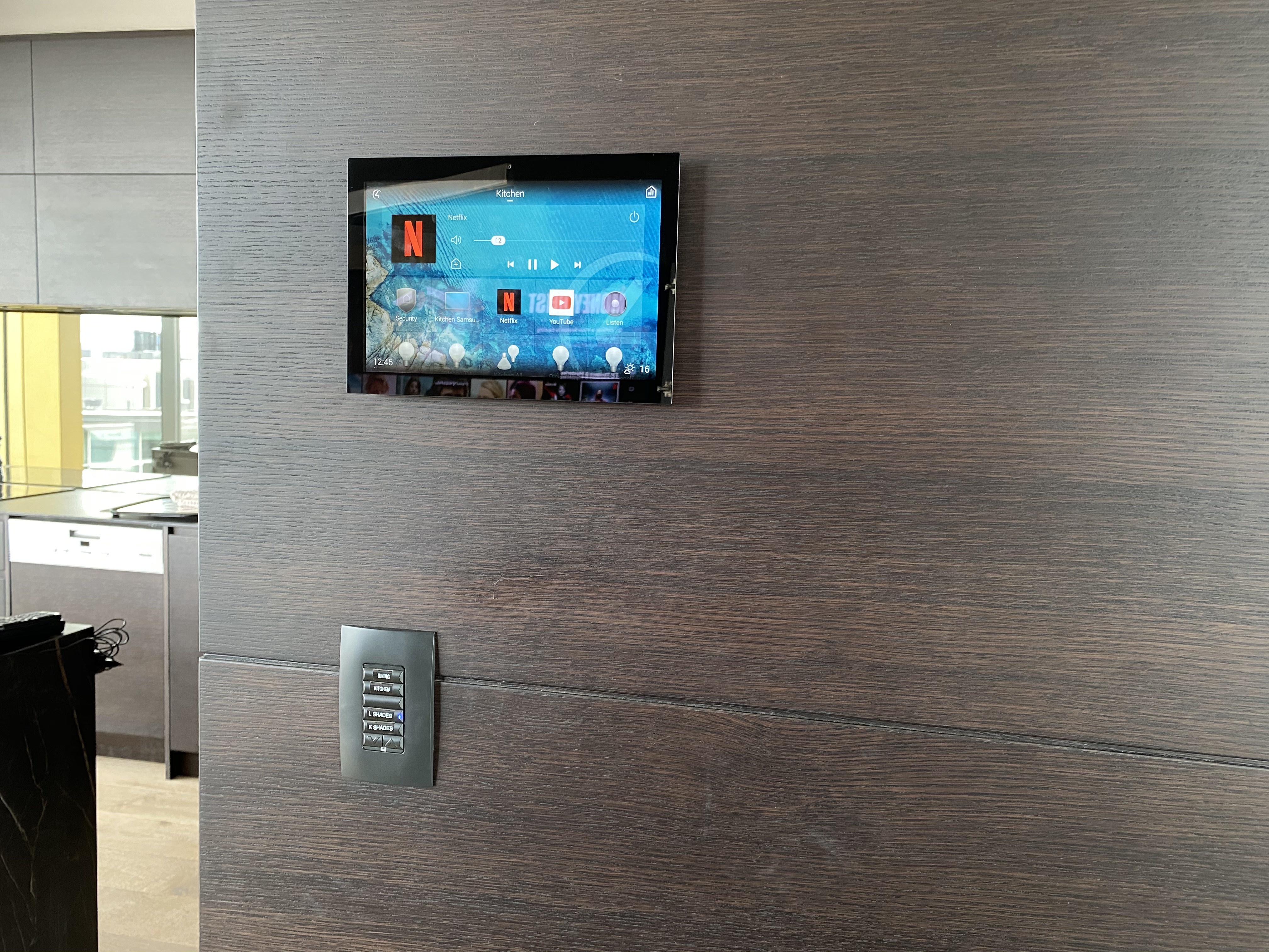 Black tablet displaying Control 4 interface for a house.